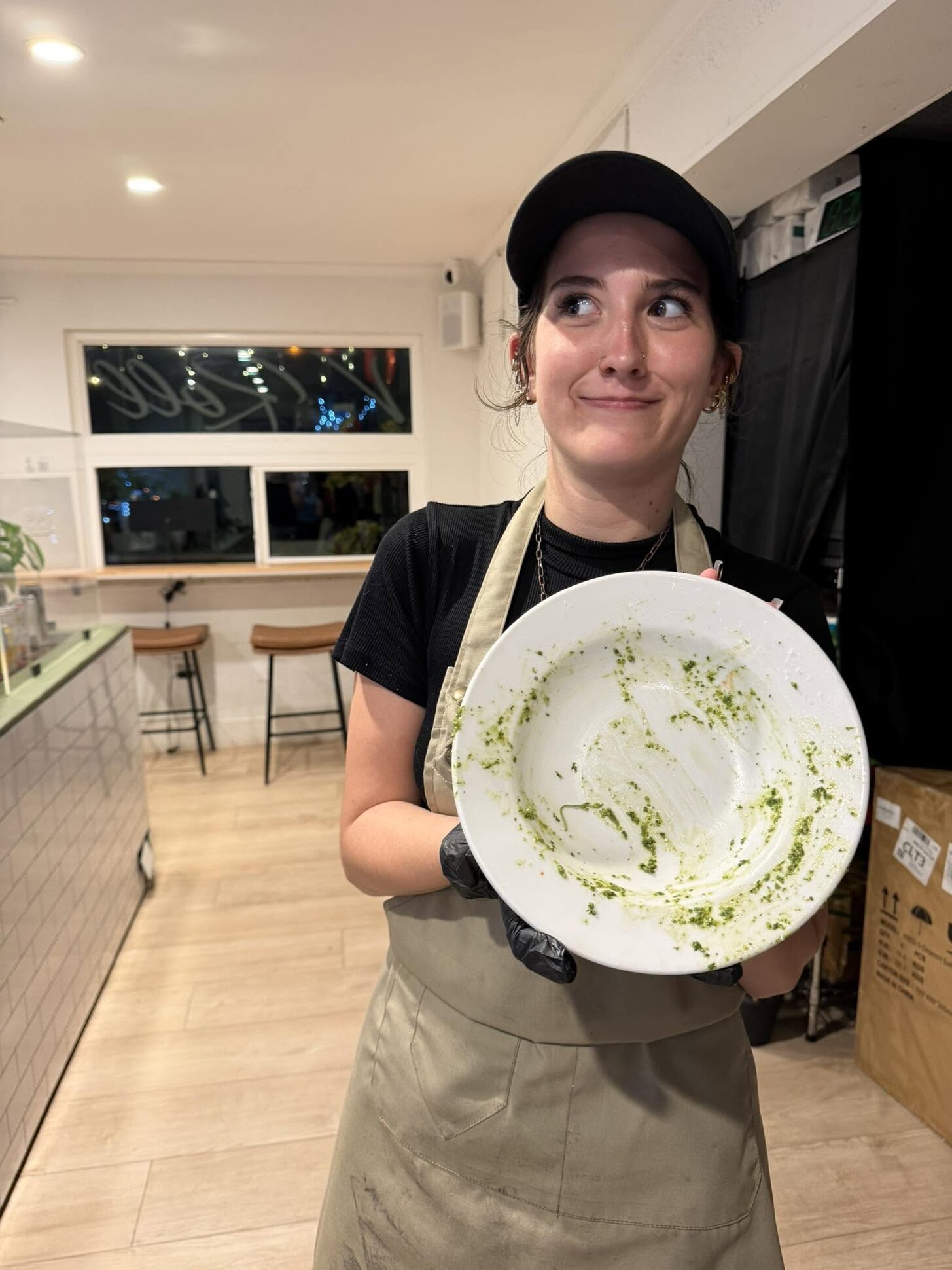 A smiling V-Roll team member holding up an empty plate