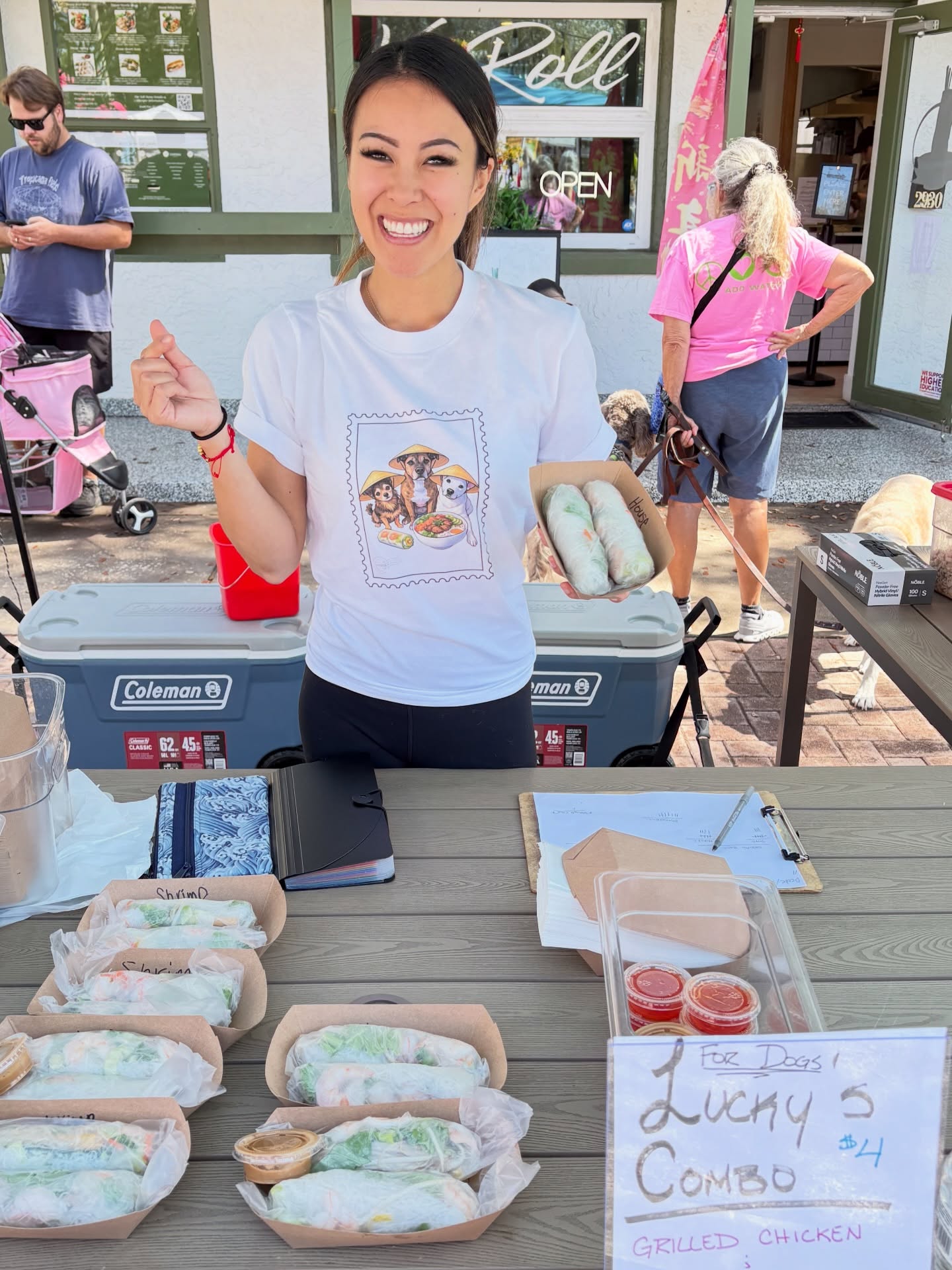 Stephanie Nghiem serving spring rolls at an outdoor community event table