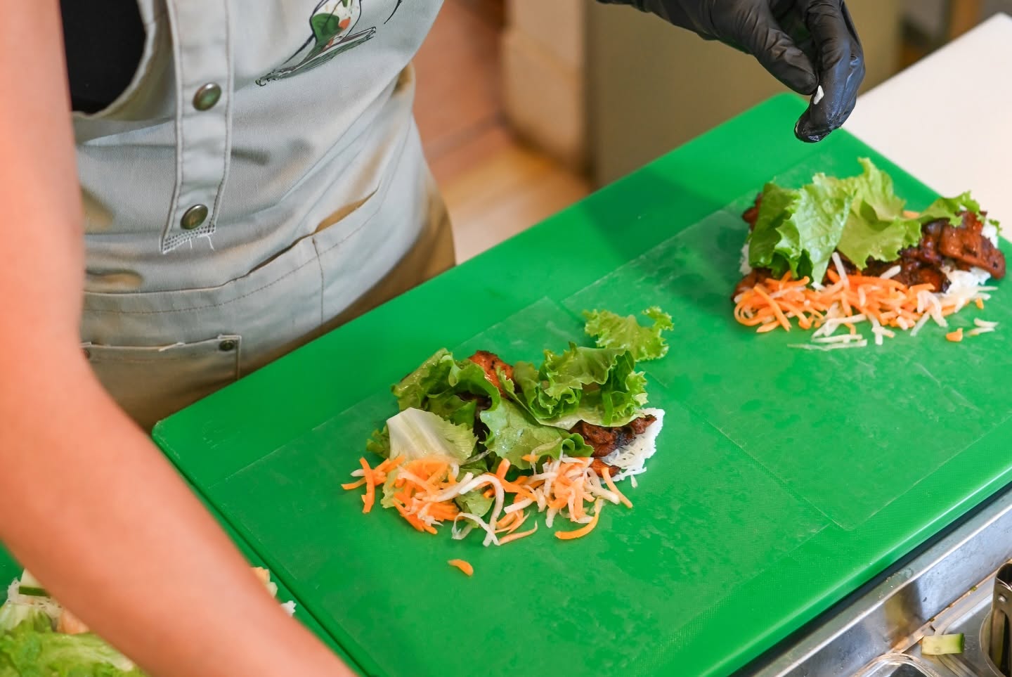 Assembling rice-paper rolls on the green counter