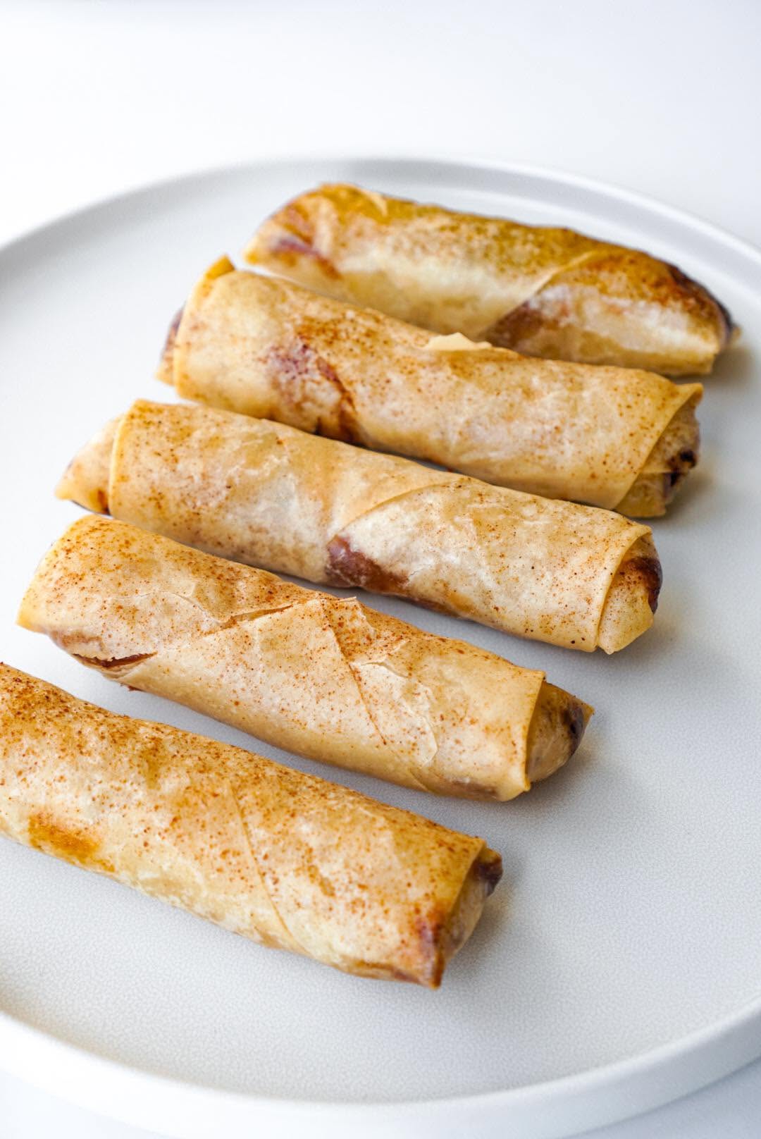 Golden egg rolls on a white plate