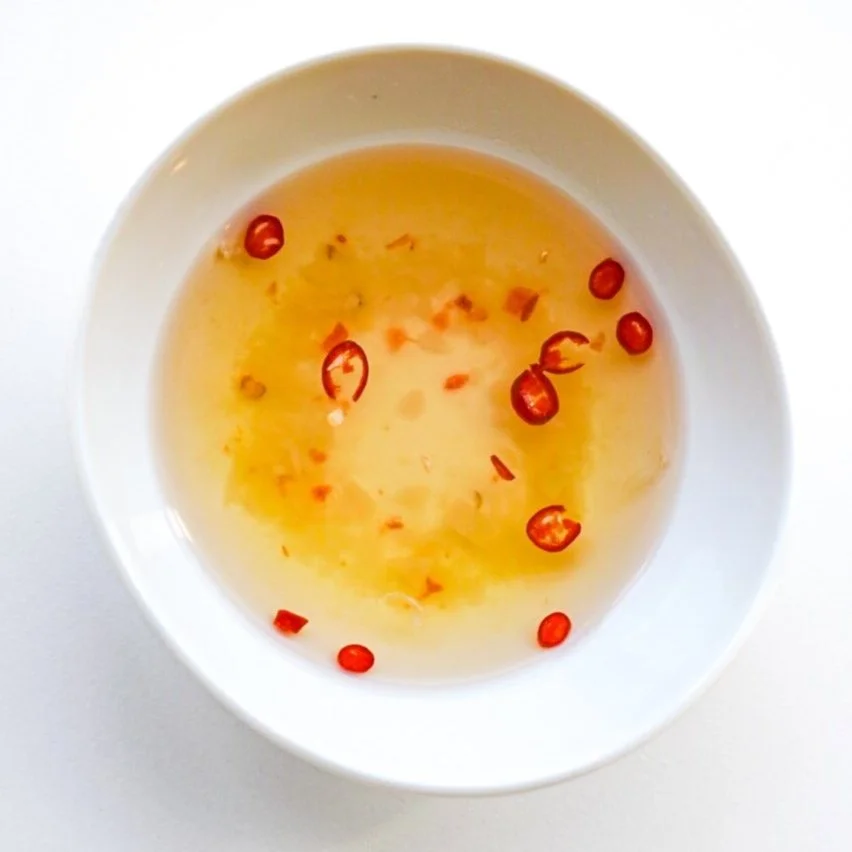 Citrus garlic sauce (nước chấm) in a white dish, from above